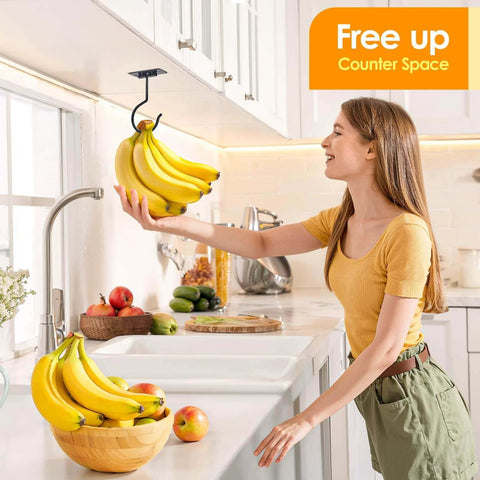 Woman in kitchen reaching for bananas hanging from under-cabinet hook with counter space saver sign