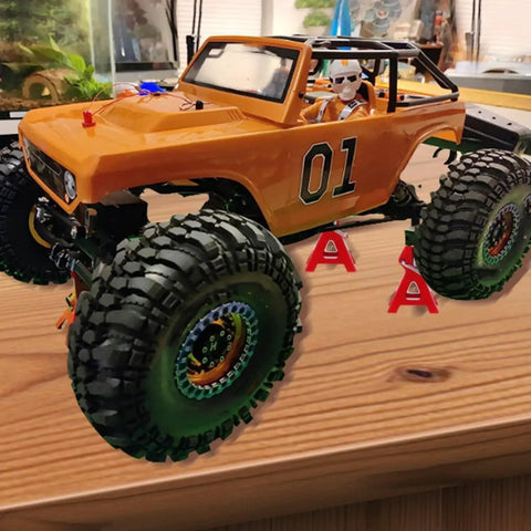 4Pcs Adjustable Metal Jack Stands for 1/10 RC Crawler Cars Climbing Jack Set supporting orange RC model on table