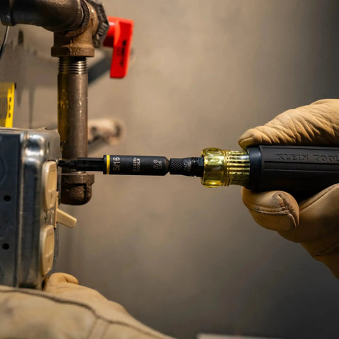 Impact Rated 11-in-1 Multi Bit Screwdriver And Nut Driver used on metal pipe, showcasing interchangeable components in action.