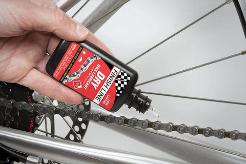 Applying Dry Bike Chain Lube Aerosol With Ceramic Dry Wax for dirt resistant performance on a bicycle chain in dry conditions