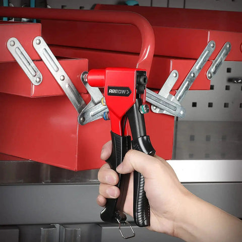 Pro Grade Hand Riveter Kit With Four Interchangeable Heads for metal work, tool held over red metal piece for installation