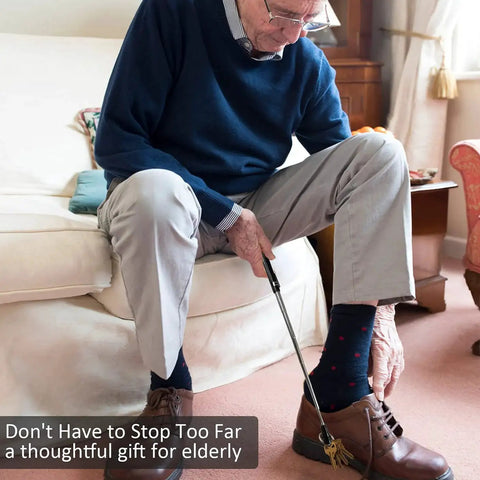 Man using a shoehorn while sitting on a sofa, demonstrating ease for elderly. Gift idea for elderly individuals.