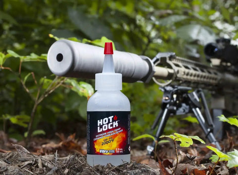 Extreme Temperature Threadlocker For Muzzle Brakes Recoil Compensators Suppressors And Turbocharger Fasteners With Ceramic Based Formula Water Soluble For Easy Removal Vibra-TITE 19960 Hot Lock Translucent High Temperature bottle in front of rifle in forest setting.