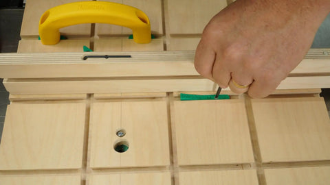 Hand adjusting MicroJig MatchFit Pop Stop 6-Pack: Pro Go-To Dovetail Track Stops on a woodworking jig with screwdriver