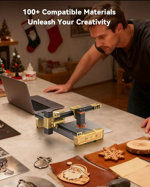 Foldable 7W Laser Engraver With 0.01mm Precision on table with wood and leather crafts, laptop nearby, holiday decorations visible.