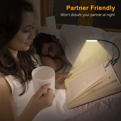 Woman reading in bed with a Rechargeable Clip On Book Light With 9 LEDs 3 Color Modes Stepless Dimming 80Hrs, partner sleeping beside her.