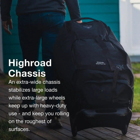 Rugged 100L Wheeled Duffel With Wingjacket Compression in use, showing oversized 110mm wheels on rough terrain, Black Osprey Sojourn Shuttle 30in 100L