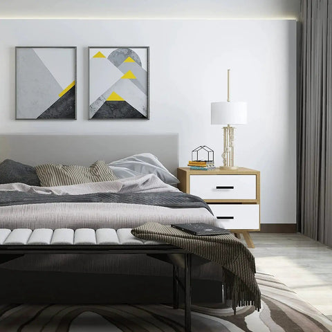 Modern bedroom with neutral tones, abstract wall art, white and wood nightstand, and a cozy bed with layered bedding.