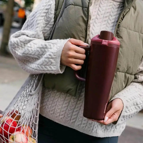 Person holding FreeSip Insulated Stainless Steel Tumbler With Built In Straw 40oz Side Handle Leak Proof in Black Cherry