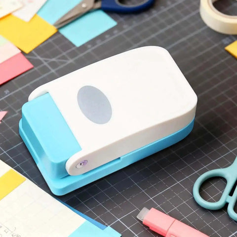Dope Tiny Paper Punch Hole Puncher For Scrapbooking And Photo Albums, Oval Shape; acrylic and metal craft tool on a desk.
