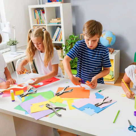 Children using 24 Pack Handheld One Hole Punches, No Fuss One Quarter Inch Six Millimeter Metal Paper Puncher For Tags, Tickets, Labels