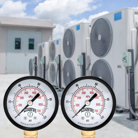 2 Inch Dial Dry Pressure Gauge With Brass Internals And Black Steel Case Dual Scale 0 To 100 Psi And KPa in front of HVAC units