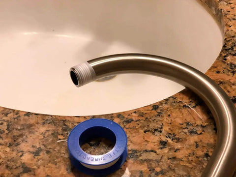 Pipe with Pro Grade PTFE Thread Seal Tape for Plumbers 1 Inch by 520 Inch next to a sink, showing leak-proof sealant use.