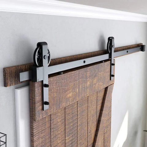 Heavy Duty Sliding Barn Door Hardware Kit in Black with Industrial Wheel Hangers, fits 36 to 40 inch wide panels, installed view.