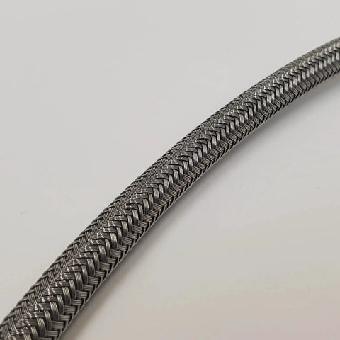 Close-up of braided stainless steel oil line from Chrome Rocker Box Oil Pressure Gauge Mount Kit for 1984-1999 Harley Big Twin EVO.