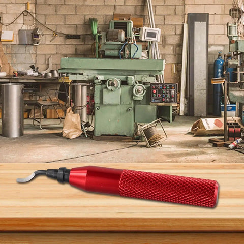 Versatile RB3000 Deburring Tool Set with red ergonomic handle on workbench, shown in workshop setting with CNC machine in background.