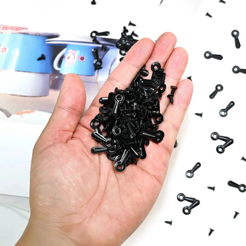 Hand holding black 100 Pcs Metal Picture Frame Turn Button Fasteners With Screws For Backing Clips Turn Buttons Set Black Finish.
