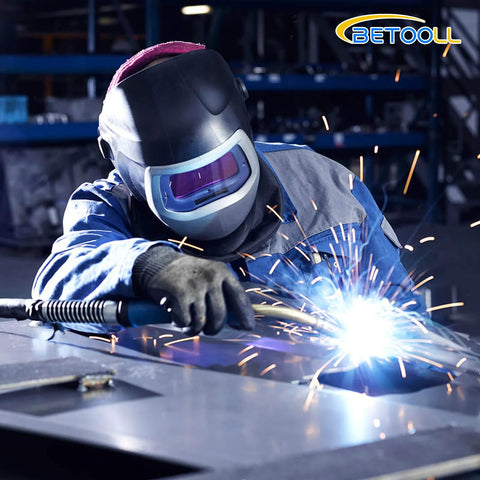 Welding welder in action: protective helmet, blue coveralls, sparks on metal; BETOOLL logo.