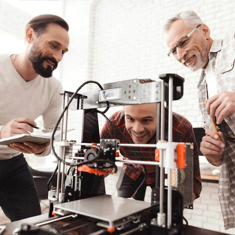 Three men working on a 3D printer setup, using 480 Piece M4 Screws Assortment Kit For 3D Printer And DIY Projects, indoors.