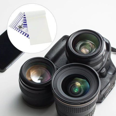 Camera lenses and booklet with Lens Cleaning Paper Sheets For Cameras Eyeglasses And Screens 100 Pack Booklets displayed.