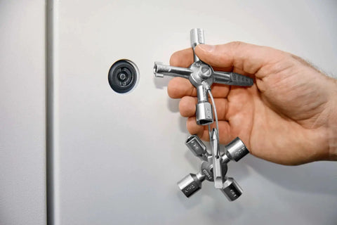 Hand holding TwinKey Multifunctional Spanner Kit With Magnetic Eight Arm Two By Four Way Spider Keys for control cabinets.