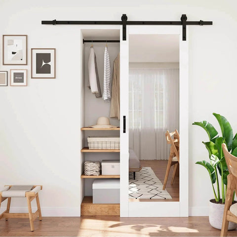 Space-Saving Barn Door With White Primed Glass Mirror Panel And Solid Wood Frame, Dual-Purpose Full-Length Dressing Mirror With Half-Frosted Glass For Privacy And Light Diffusion, Installation Hardware Included, 28 By 80 Inches installed in a bedroom closet.