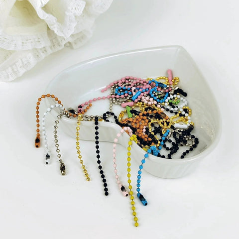 Assorted colorful beads chains in a bowl for crafts and keychain projects, similar to 50 Pcs 4 Inch Ball Beads Chain With Connectors.