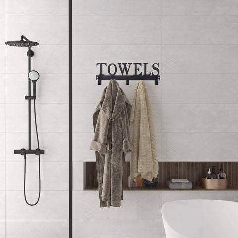 Over-the-door towel rack, black metal with 3 hooks and towel bar, mounted in a modern bathroom.