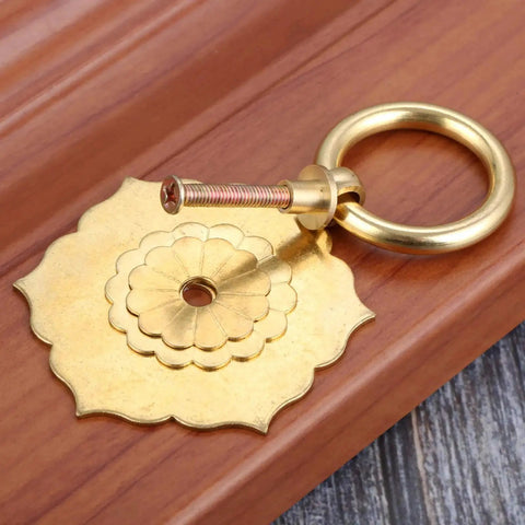 Antique Brass Ring Pulls For Cabinets And Doors Hexagon Flower Design on wooden surface, single pull with screw visible for easy installation.