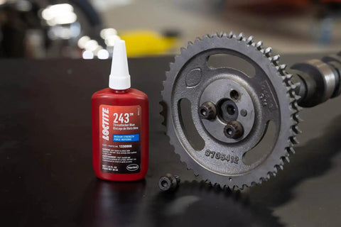 Medium Strength Surface Insensitive Threadlocker For 1/4 To 3/4 Inch Fasteners bottle next to metal gear.