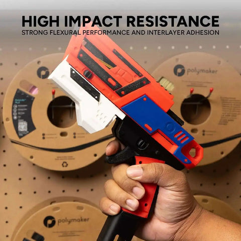 Hand holding a 3D printed tool made with PLA Pro 3D Filament White 1.75mm 1kg, Beefed Up High Impact Tough PLA, against spools of filament.