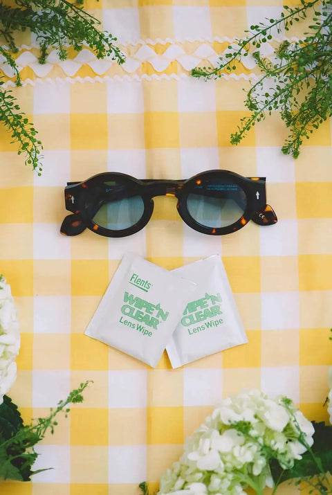 Pre-Moistened Lens Wipes Assorted 20 Count for Glasses and Sunglasses USA Made shown with sunglasses on a yellow checkered cloth.