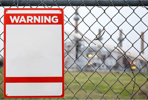 Heavy Duty Metal Caution Sign 8x12 Inches For Indoor And Outdoor Use Fire Hazard Warning Plaque on a fence in front of industrial area