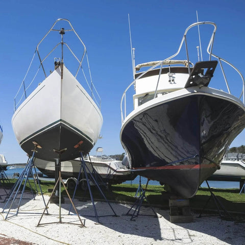 Two boats on stands by the shore, ideal for Marine Grade Lubricant and Penetrating Oil for Boats and Gear NSF H1 Marine Formula use.