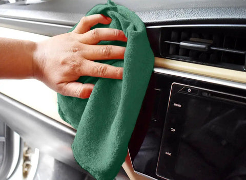 Hand using Heavy Duty Shop Towels 50 Pack Green Terry Cloth Rags For Car Detailing And Home Cleaning Highly Absorbent Reusable Washable Towels