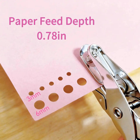 Close-up of 2 Pack Mini Circle Hole Punches One Quarter Inch And One Eighth Inch With Pink Soft Grip Handles used on pink paper