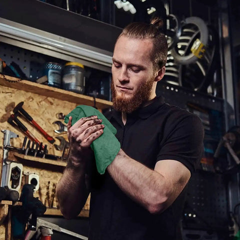 Man in workshop using Heavy Duty Shop Towels 50 Pack Green Terry Cloth Rags For Car Detailing And Home Cleaning Highly Absorbent Washable Towels