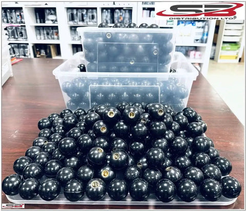 Heavy Duty Black Phenolic ABS Female Ball Knob With Brass Insert 3/8-16 Thread piled in bins on a warehouse shelf.