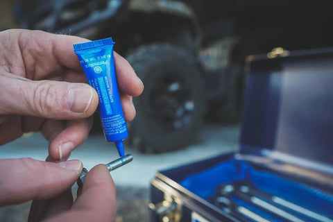 Applying Blue Medium Strength Threadlocker for Fasteners 1 Quarter Inch To 3 Quarter Inch 6mL by Permatex to a metal bolt.