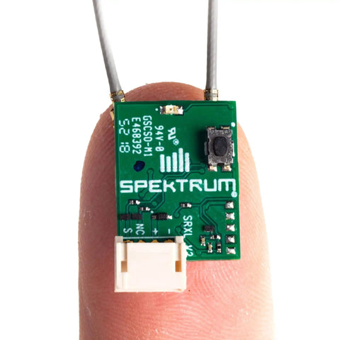 Ultra Tiny SRXL2 DSMX Serial Micro Receiver for RC Gearheads, Model SPM4650, displayed on fingertip, showcasing compact size