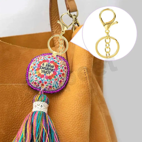 28Pcs 7 Color Lobster Claw Clasps With Key Chain And Flat Split Keychain Ring Set For Purses, Bags And DIY Crafts attached to a bag.