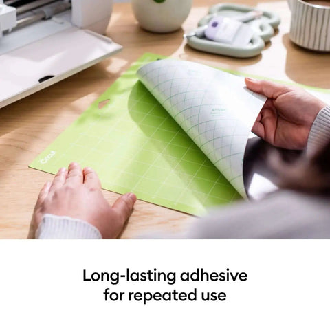 Person peeling back a green StandardGrip 12x12 Cutting Mat Pack for Explore and Maker Machines, 6 Pack, Cricut Compatible Mats