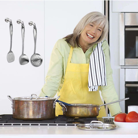 Woman cooking in kitchen with stainless steel utensils and pots on the stove