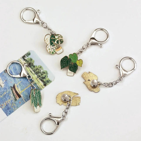 6 Pack Pin To Keychain Converter Locking Backs Turn Pins Into Keychains For Display On Bags And Accessories Enamel Pin Backing Brooch Holder Durable Metal Construction For Everyday Style And Easy Show Off featuring four converters attached to plant-themed pins.