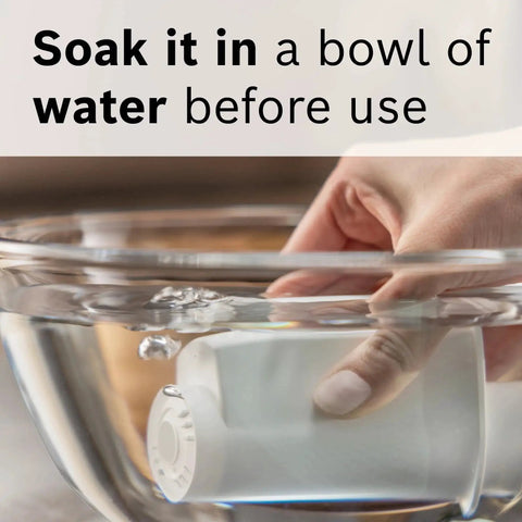 White water filter cartridge for espresso machines soaking in a clear glass bowl of water
