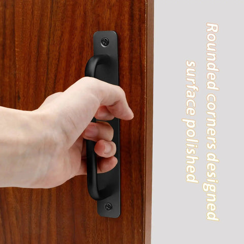 2 Pack Aluminum Alloy Sliding Barn Door Handle With Plate 128mm Center To Center Hole Spacing 5.9 Inch Total Length Black Finish Suitable For Kitchen Cabinet Bathroom And Closet Doors Durable And Easy To Install, installed on a wooden door with hand gripping.