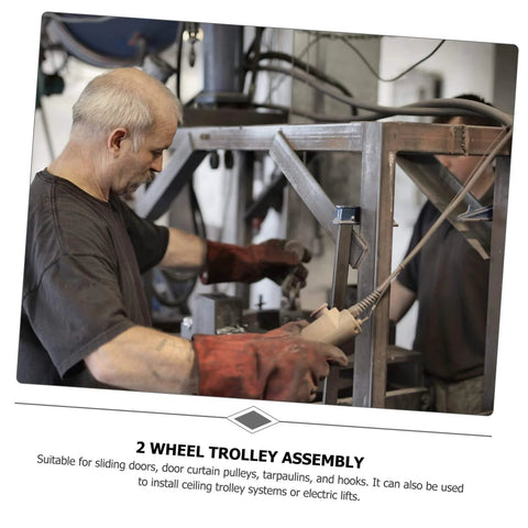 Man assembling 2 wheel trolley system for sliding doors, showing installation process in workshop with heavy-duty equipment.