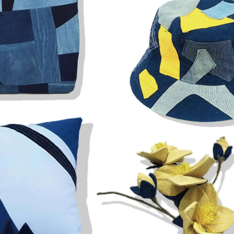 Blue and yellow patchwork hat, blue geometric pillow, and fabric flowers in various shades of blue and yellow.