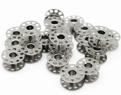Metal sewing machine bobbins, front view, silver with perforated flanges