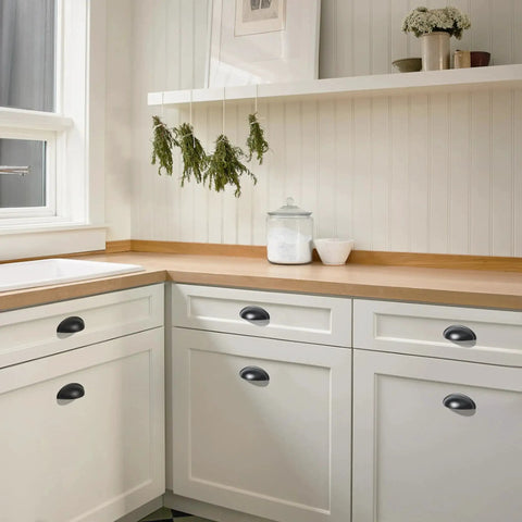 Matte Black Cup Pulls Set of 10 for Cabinets and Drawers Three and Eleven Sixteenths Inch Length installed on white kitchen cabinets